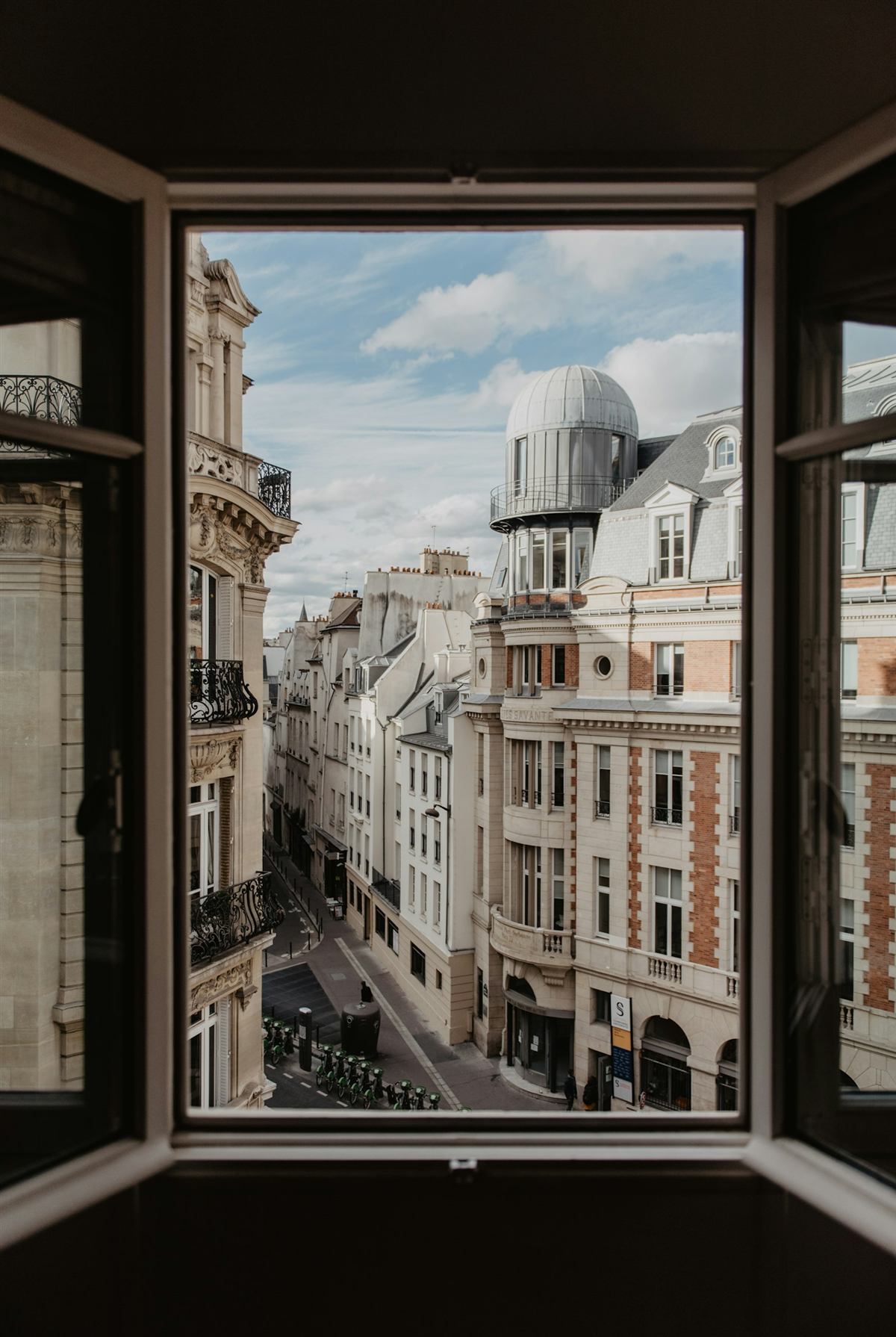 Blick aus einem offenen Fenster auf eine Altbaustraße