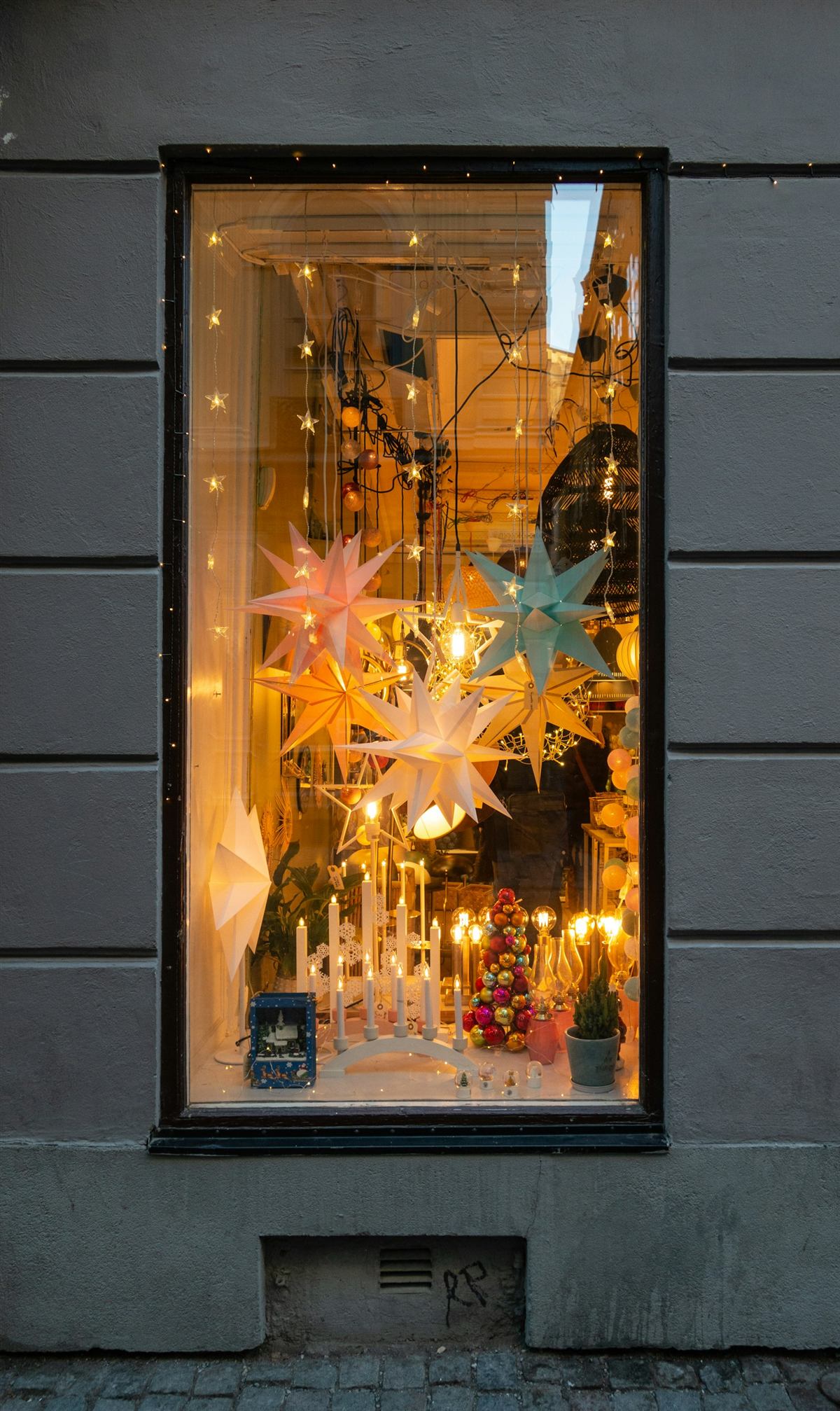 Beleuchtetes Schaufenster mit Sternendekoration am Abend